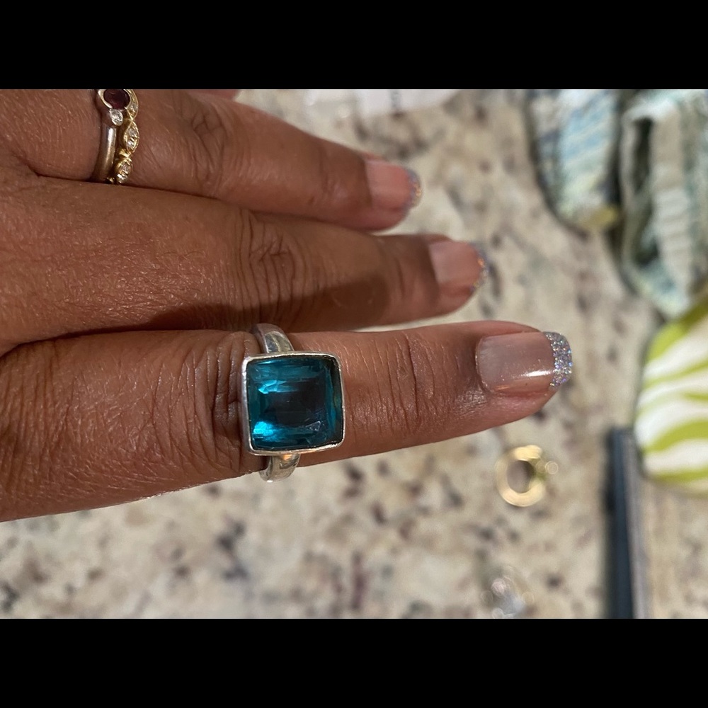 Sterling sliver ring with teal color center. Material of center stone unknown.